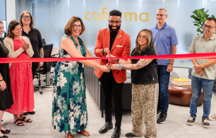 Coforma employees cutting a ribbon at their new office headquarters